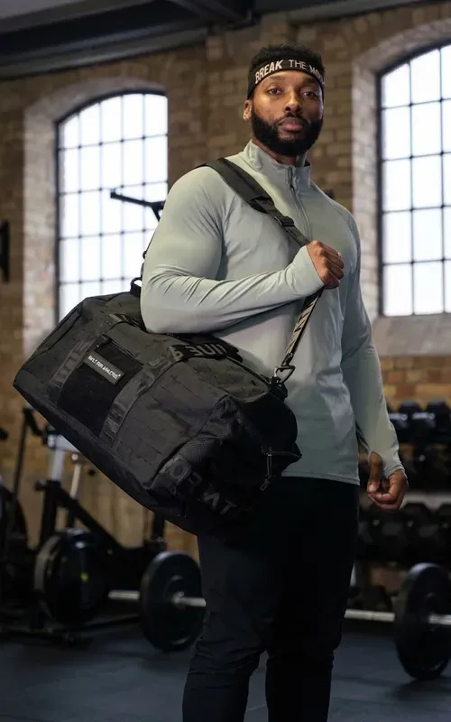Black gym duffle carried in a training studio