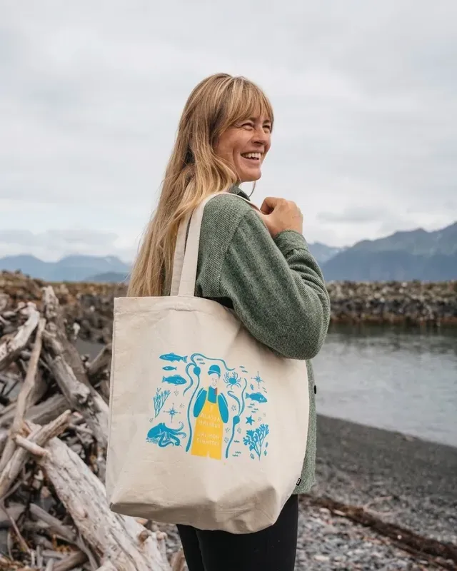 Printed organic-cotton tote carried on a shoreline