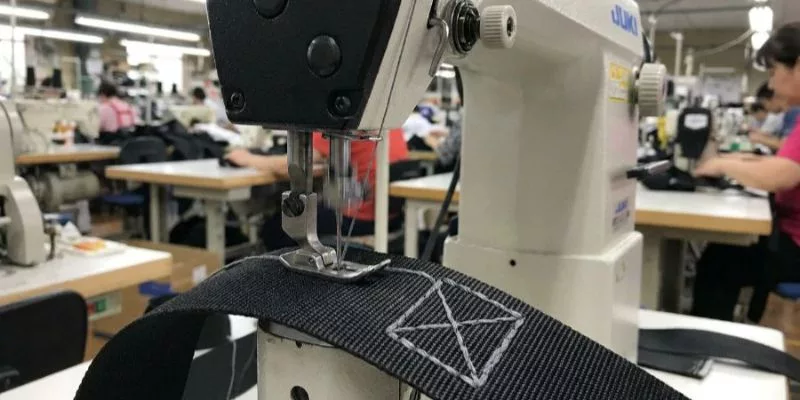 2. 工場労働者が工具バッグのウェビングに頑丈なボックスXステッチを縫っている