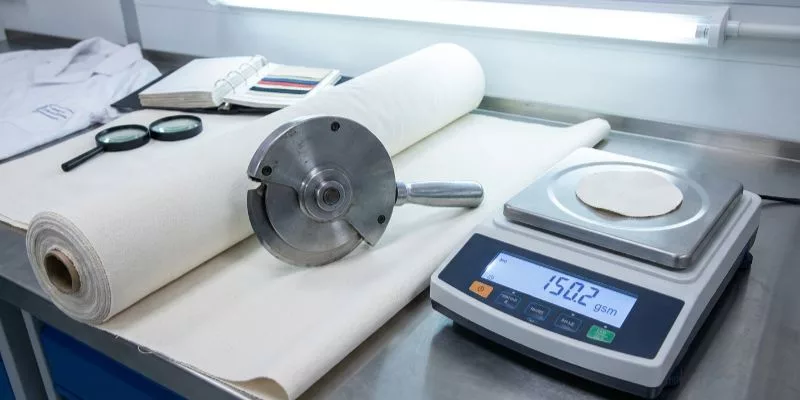 Coupe-tissu circulaire GSM et balance numérique pour tester le poids de la toile dans un laboratoire de contrôle qualité
