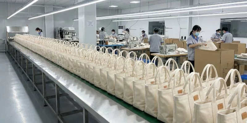 Ligne de production terminée présentant des centaines de sacs en toile personnalisés de haute qualité ayant passé l'inspection finale.