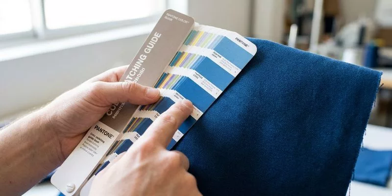 Porównanie wzornika kolorów Pantone z kawałkiem barwionego na niebiesko płótna