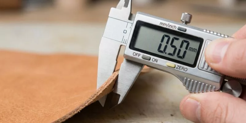 Digital caliper measuring leather thickness to 0.50mm with high precision.