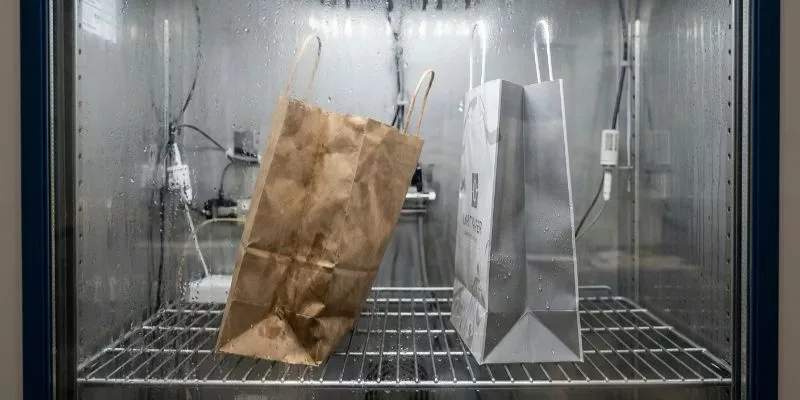 Humidity chamber test comparing moisture resistance between untreated kraft paper and laminated art paper.