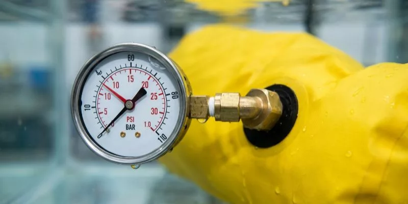 Hydrostatic pressure gauge reading 15 PSI during a waterproof dry bag test